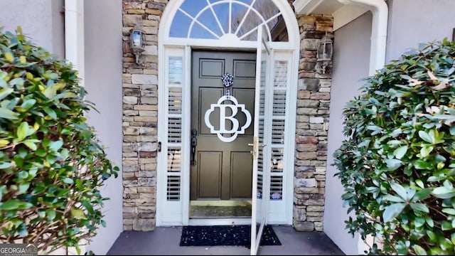 property entrance with stone siding and stucco siding