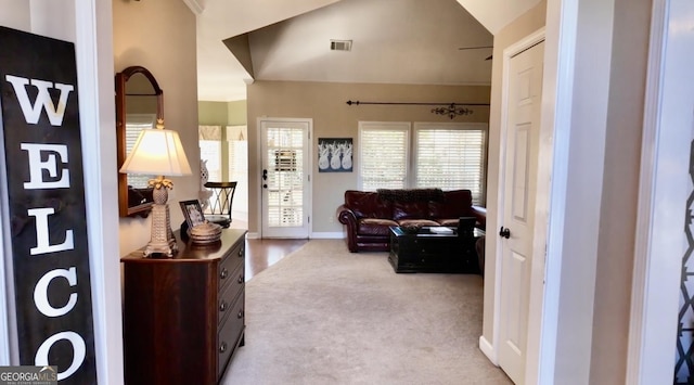 living room with visible vents, baseboards, lofted ceiling, and carpet floors