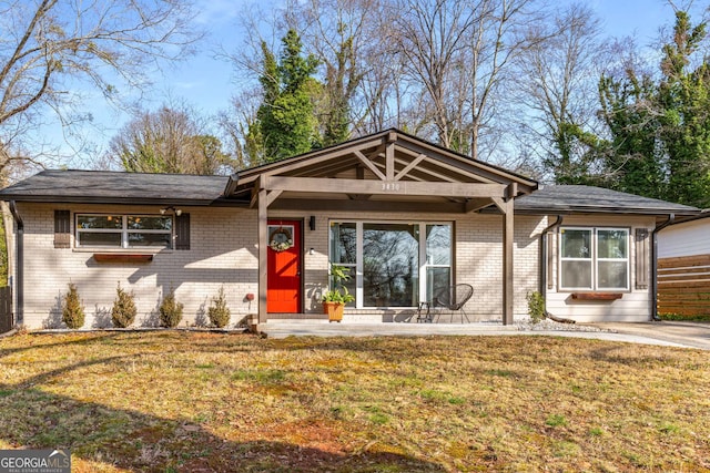 single story home featuring brick siding and a front lawn