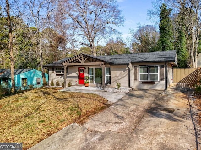 single story home featuring driveway, a front lawn, and fence