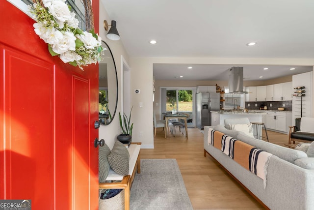 living room with recessed lighting, light wood-style flooring, and baseboards