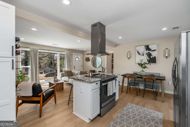 kitchen with light wood-style flooring, island exhaust hood, visible vents, and stainless steel appliances