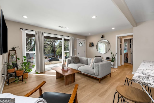 living area with recessed lighting, visible vents, baseboards, and light wood finished floors