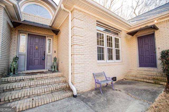 doorway to property featuring brick siding