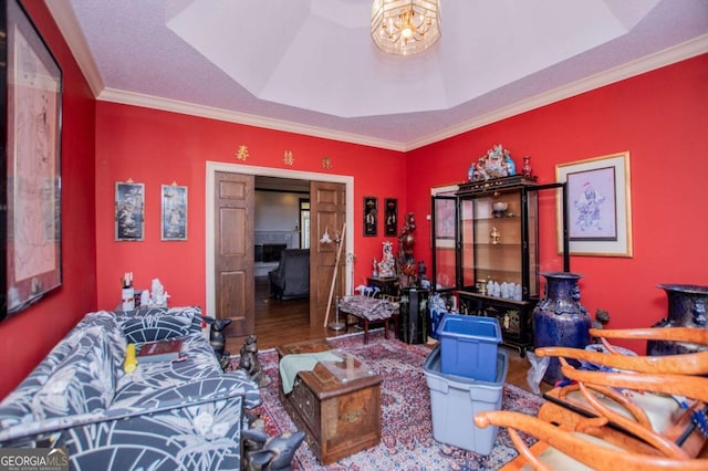 interior space featuring a tray ceiling, a notable chandelier, wood finished floors, and ornamental molding