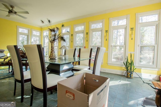 dining space with ceiling fan, baseboards, stone tile floors, and ornamental molding