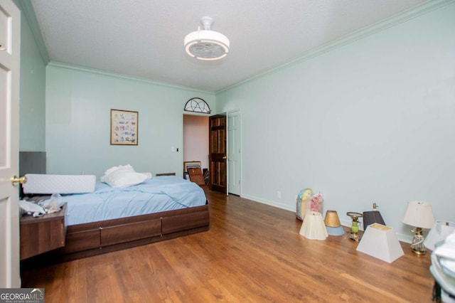 bedroom featuring wood finished floors, baseboards, and ornamental molding