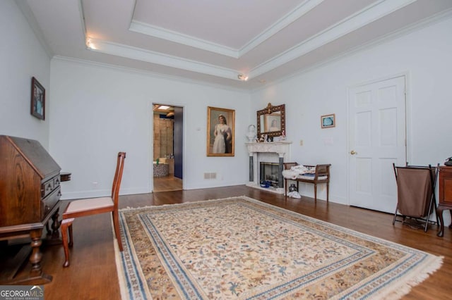 office area featuring visible vents, ornamental molding, wood finished floors, a high end fireplace, and a raised ceiling