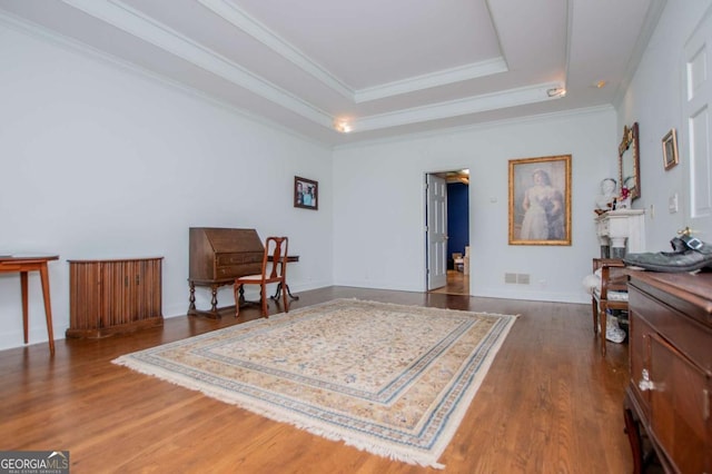 sitting room featuring a raised ceiling, ornamental molding, visible vents, and dark wood-type flooring