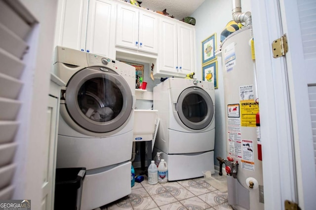 laundry room featuring light tile patterned floors, cabinet space, water heater, and washing machine and clothes dryer