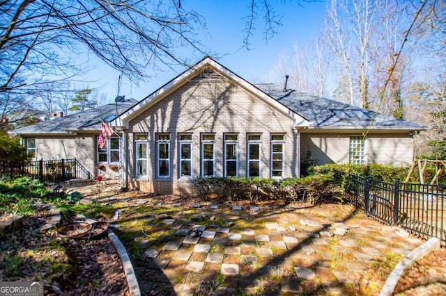 back of property featuring fence and brick siding