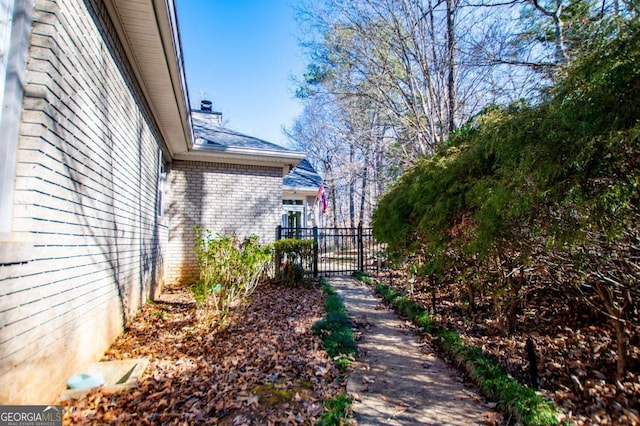 view of home's exterior with a gate and brick siding