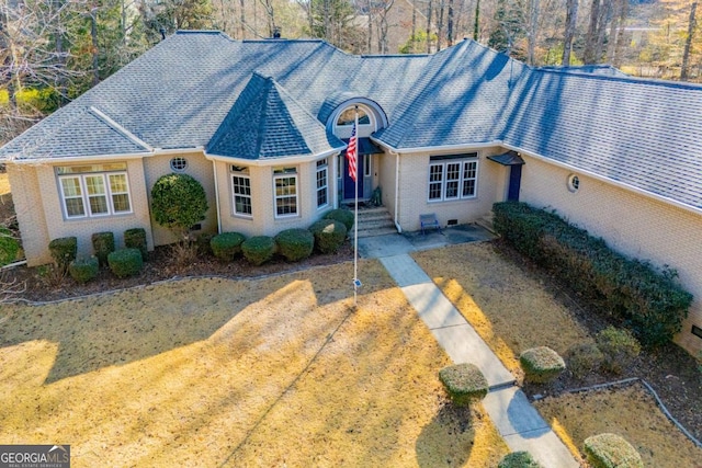 view of front of property with brick siding and roof with shingles