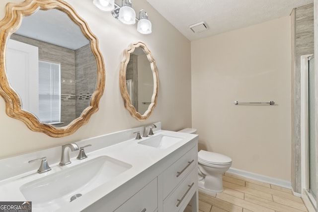 bathroom with baseboards, toilet, wood finish floors, and a sink