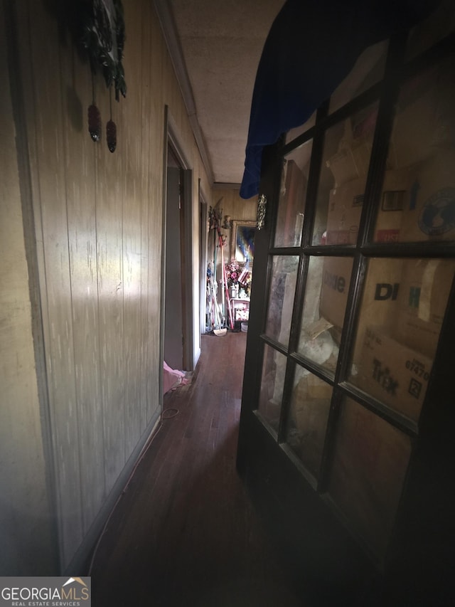 corridor featuring wood finished floors and wood walls