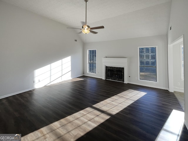 unfurnished living room with a high end fireplace, baseboards, ceiling fan, wood finished floors, and high vaulted ceiling