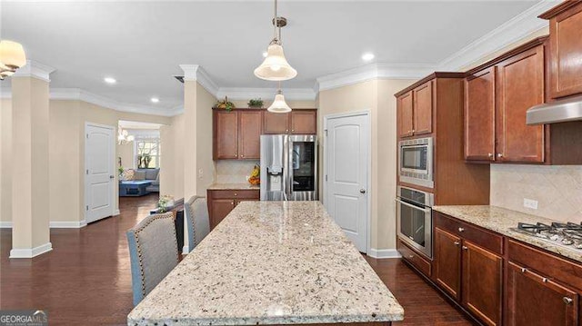 kitchen featuring light stone counters, ornate columns, dark wood finished floors, appliances with stainless steel finishes, and a center island