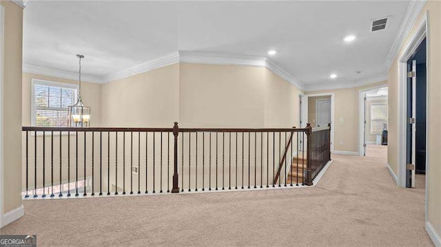 hallway with visible vents, carpet floors, baseboards, a notable chandelier, and an upstairs landing