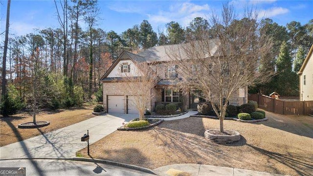 traditional home with driveway, an attached garage, and fence