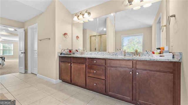 full bathroom with tile patterned flooring, double vanity, a shower with shower door, and a sink