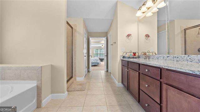 bathroom with tile patterned flooring, a shower stall, a bath, and vanity