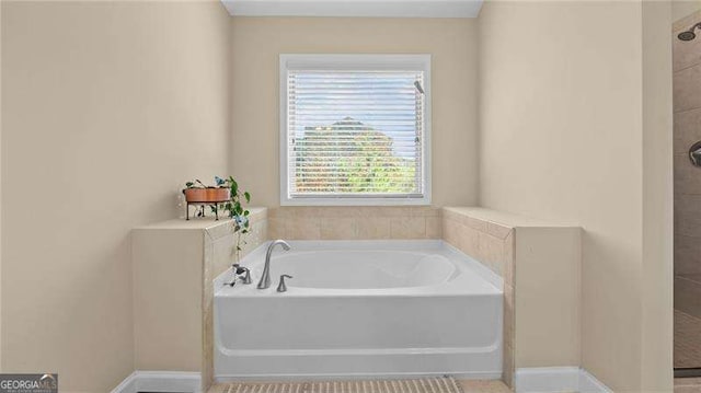 full bath with a garden tub and tiled shower