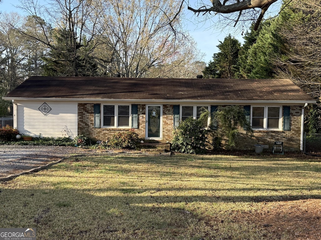 ranch-style home with a front yard and brick siding