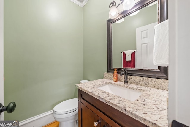 half bath featuring baseboards, toilet, and vanity