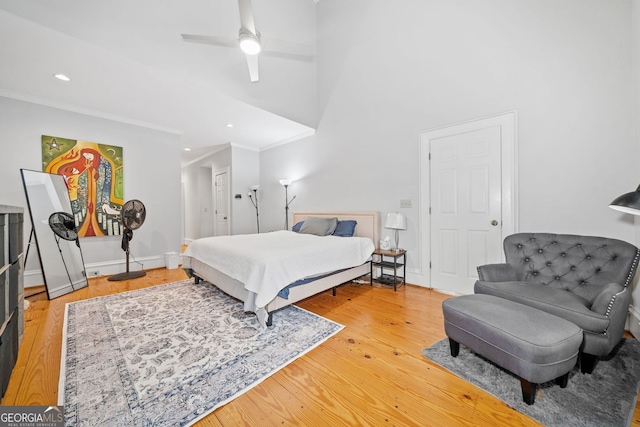 bedroom with crown molding, baseboards, and light wood finished floors