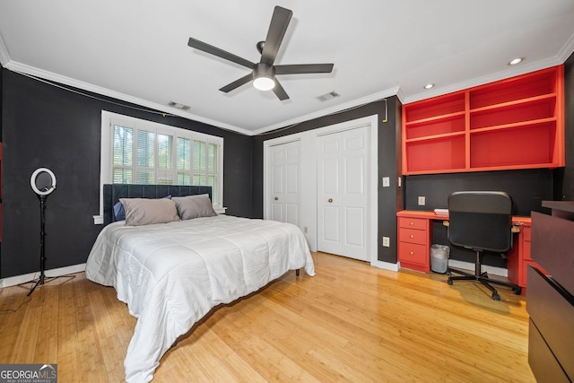 bedroom featuring light wood finished floors, visible vents, and crown molding