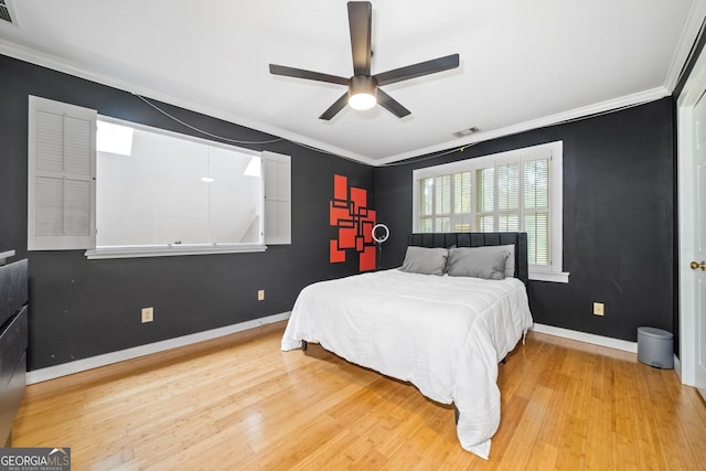 bedroom with crown molding, baseboards, and light wood finished floors