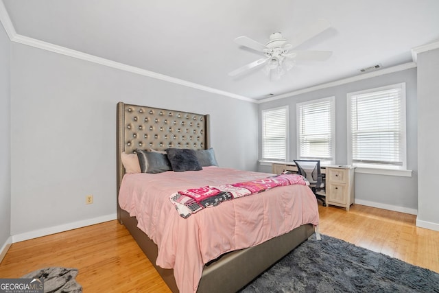 bedroom featuring visible vents, baseboards, light wood-style flooring, and crown molding