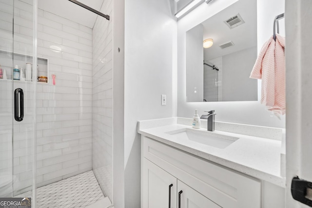 bathroom with visible vents, vanity, and a shower stall