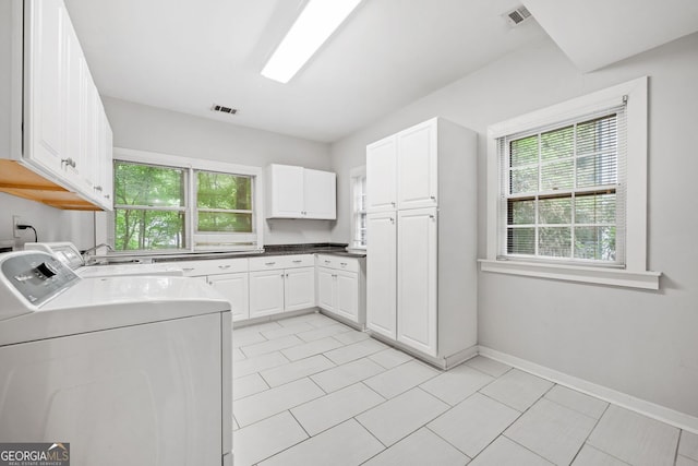 laundry room featuring a sink, cabinet space, visible vents, and washing machine and clothes dryer