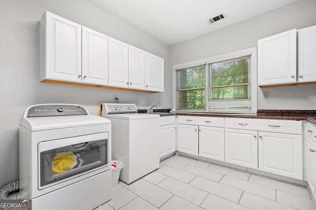 clothes washing area featuring cabinet space, visible vents, independent washer and dryer, and light tile patterned floors