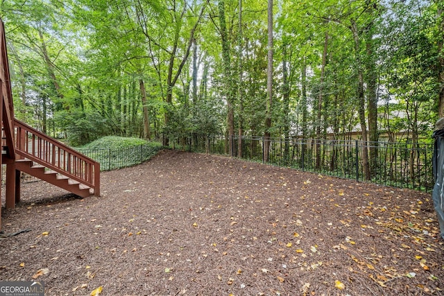 view of yard featuring stairs and fence