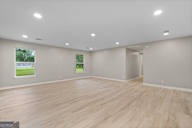 unfurnished room featuring healthy amount of natural light, light wood finished floors, baseboards, and recessed lighting