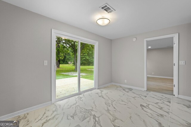 spare room with light marble finish floors and baseboards