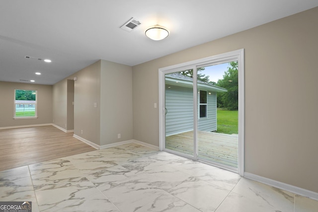 spare room featuring marble finish flooring, baseboards, and recessed lighting