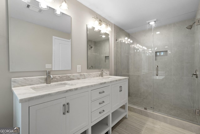 bathroom with a stall shower and double vanity