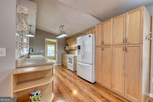 kitchen featuring a sink, open shelves, white appliances, light wood-style floors, and vaulted ceiling