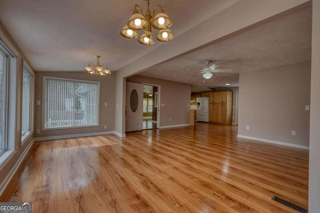 unfurnished living room with visible vents, a textured ceiling, and light wood-type flooring