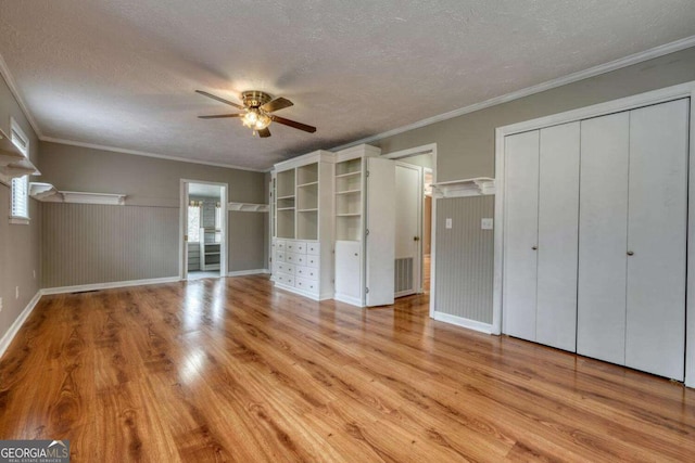 unfurnished bedroom with visible vents, ornamental molding, a ceiling fan, a textured ceiling, and light wood-style floors