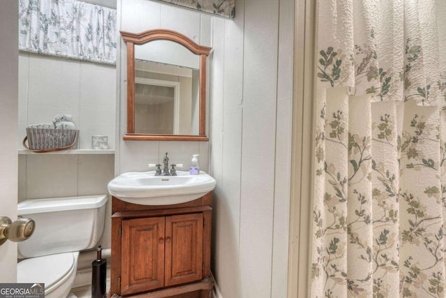 bathroom featuring a shower with curtain, toilet, and vanity