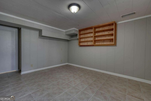 finished basement with tile patterned floors, baseboards, and visible vents