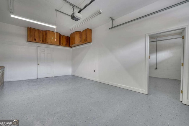 garage with a garage door opener and concrete block wall