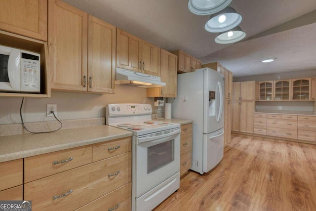 kitchen with under cabinet range hood, white appliances, light brown cabinetry, and light countertops