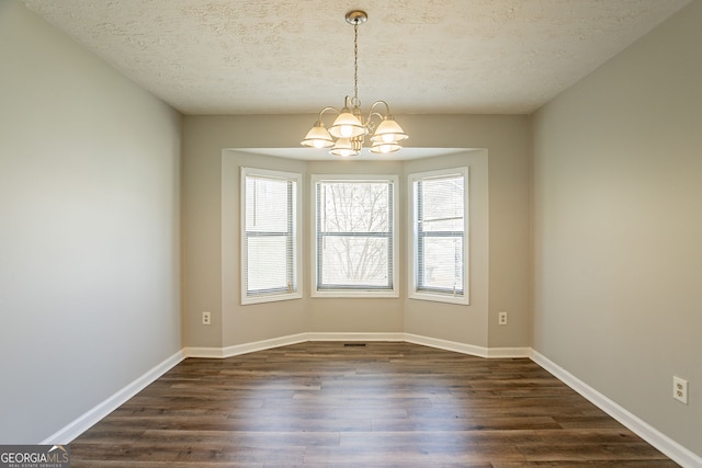 6265 Stoney Cv, Austell, GA 30168 - empty room with a chandelier, dark wood-type flooring, and a textured ceiling