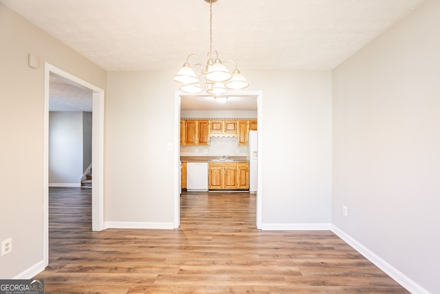 6265 Stoney Cv, Austell, GA 30168 - unfurnished dining area featuring a chandelier, light wood-type flooring, and stairs