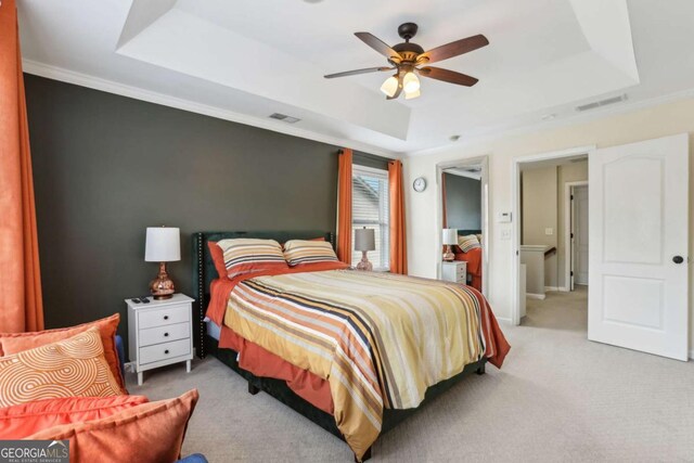 carpeted bedroom featuring visible vents, crown molding, and a raised ceiling